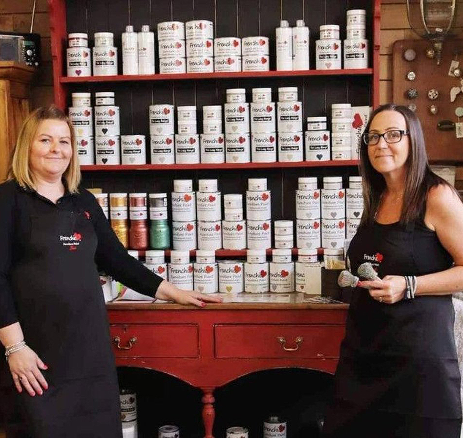 Lilac Tree Interiors all about us Lisa and Sarah in front of Frenchic paint range